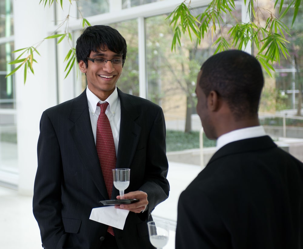 Students in business attire interacting at a networking event