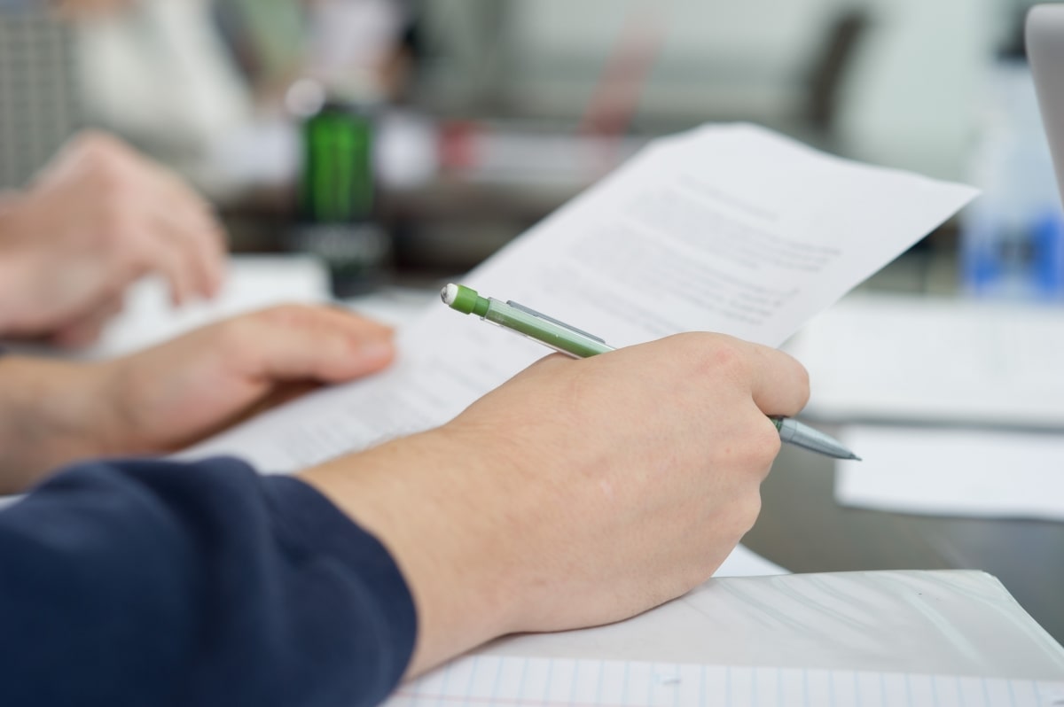 A pair of hands holding paper and pencil