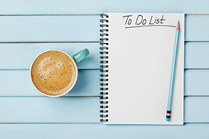 Cup of coffee sitting next to a blank to-do list
