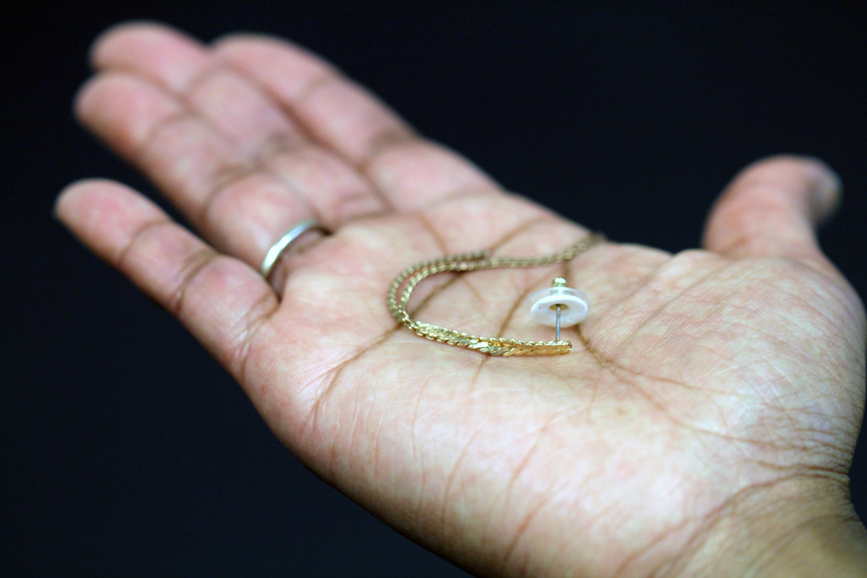 An earring is shown paired with a transdermal patch backing. The white ring is the patch containing the contraceptive hormone. (Credit: Mark Prausnitz, Georgia Tech)