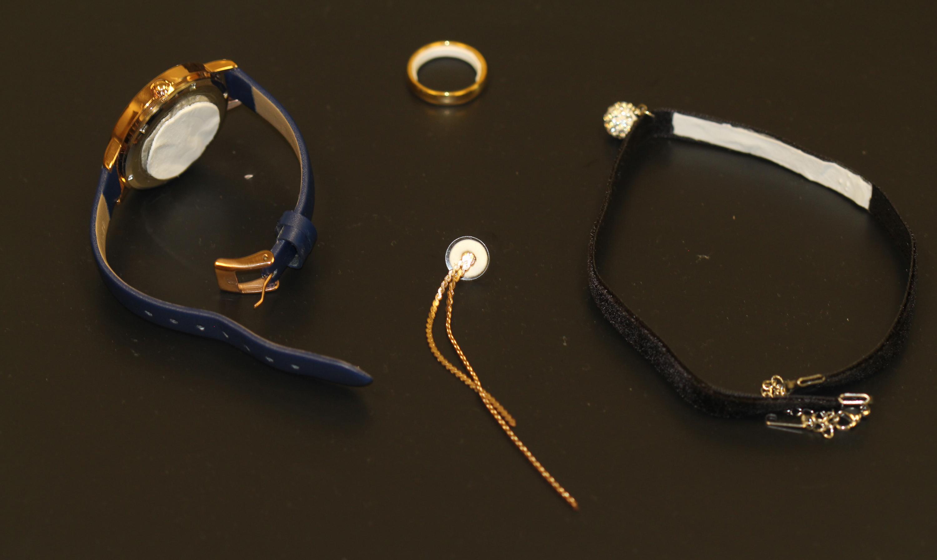 Image shows potential contraceptive jewelry, in clockwise order, a pharmaceutical watch, ring, choker necklace and earring. In each case, a white contraceptive patch material is applied to a part of the jewelry that would be in contact with the skin. (Credit: Mark Prausnitz, Georgia Tech)