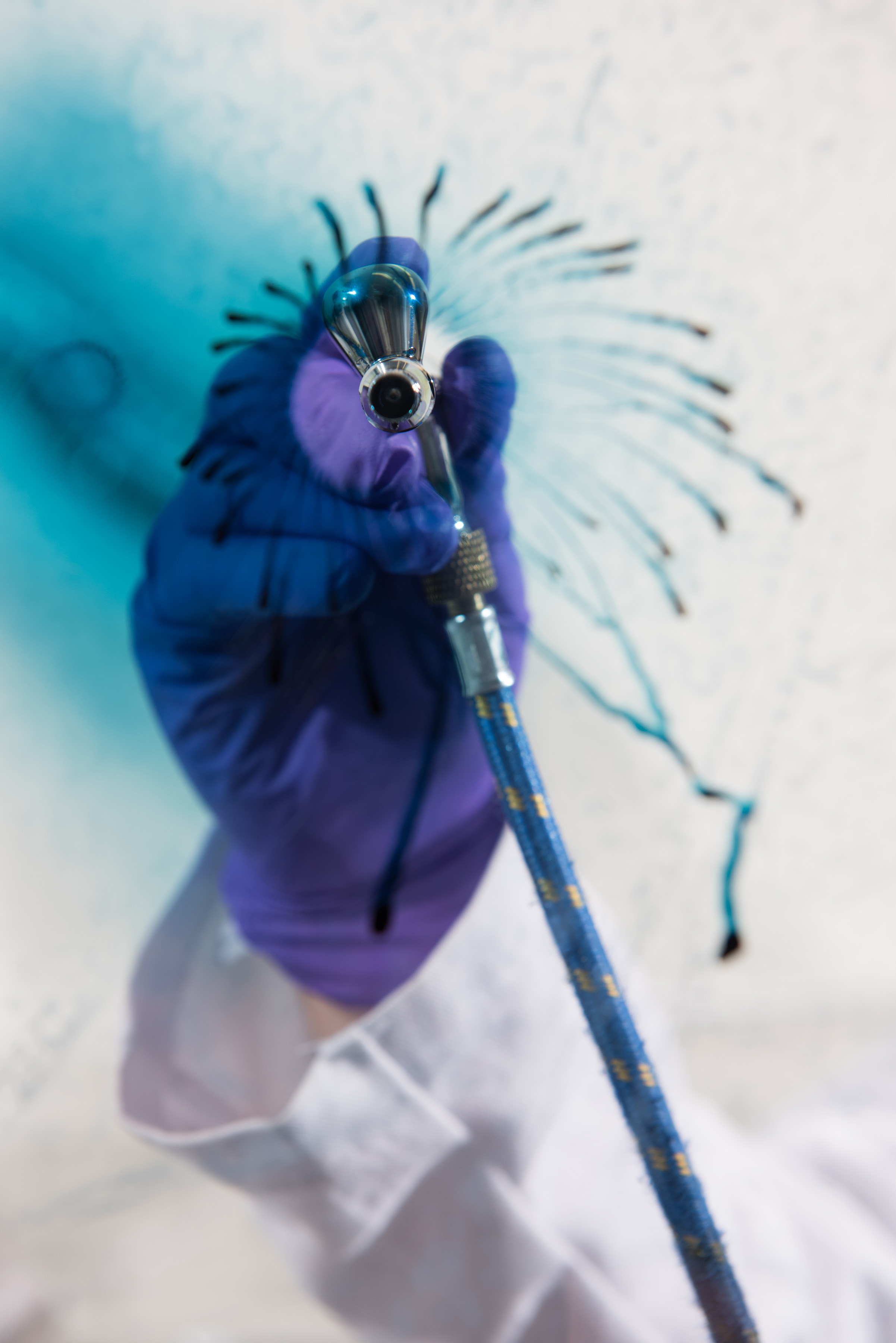An airbrush is used to apply a film of electrochromic polymers to this clear surface. (Credit: Rob Felt) An airbrush is used to apply a film of electrochromic polymers to this clear surface. (Credit: Rob Felt)