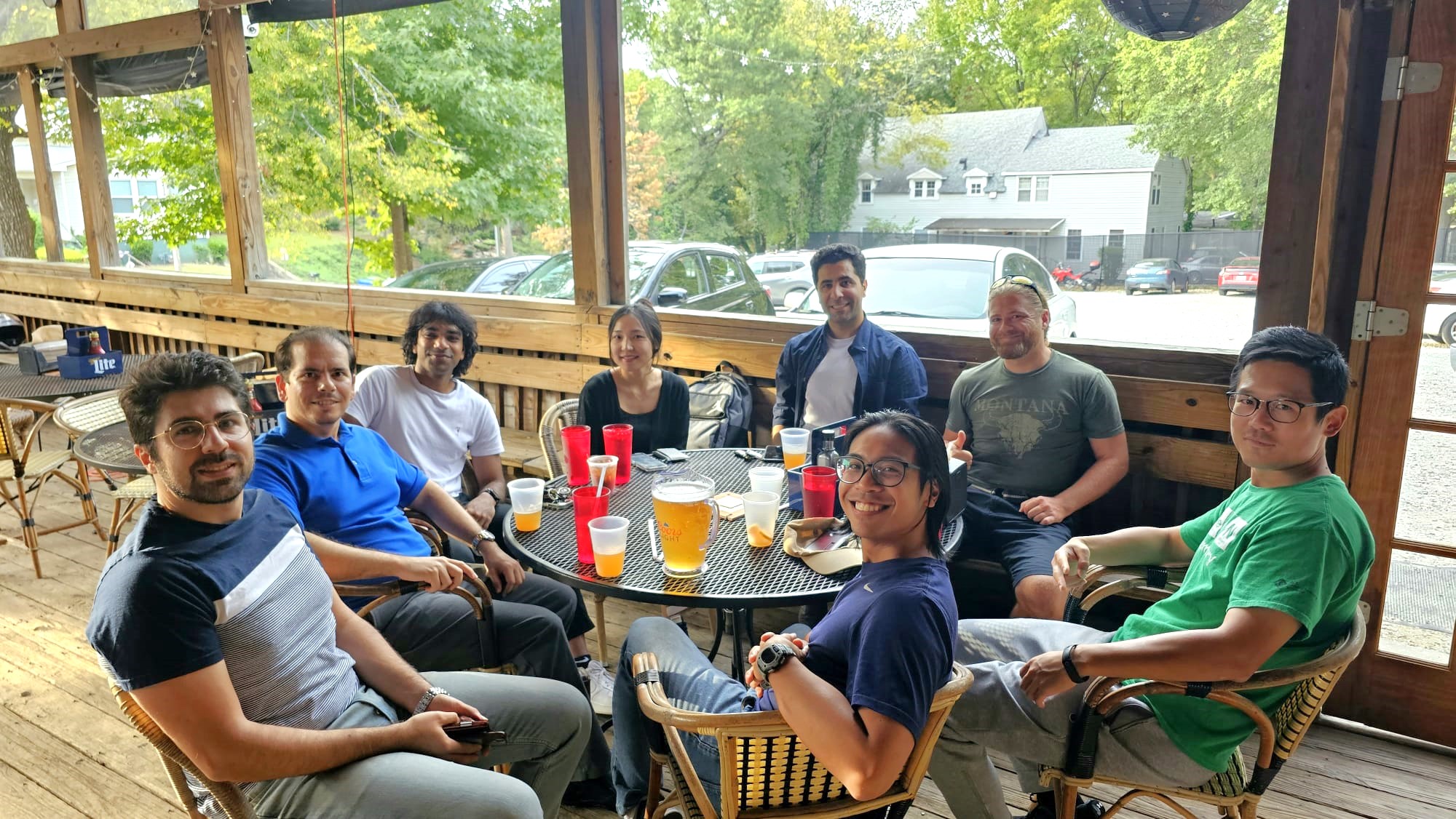A group of postdocs around a table sharing food and beers.
