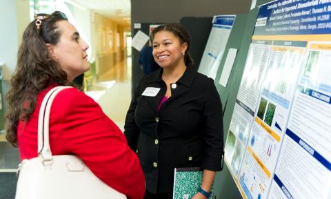 Postdoc Michelle Gaines presents her poster to Yukat Gazi, associate dean in Professional Education.