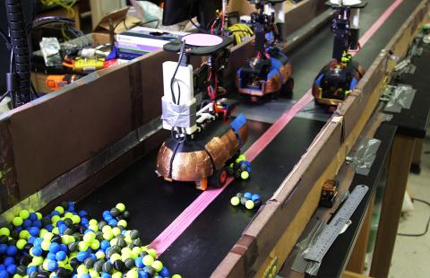 Photograph shows three robots working in close proximity in a confined space. Adding a fourth robot created a traffic jam that brought digging to a halt. (Georgia Tech photo)