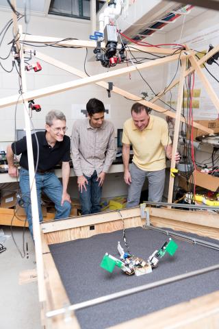 Researchers (l-r) Richard Blob, Ben McInroe and Dan Goldman examine a robot named MuddyBot whose locomotion was inspired by the mudskipper. The robot has two limbs and a powerful tail to move though a trackway that can be raised to simulate granular slopes. Blob is a professor at Clemson University; McInroe was a student at Georgia Tech when the research was conducted, and Goldman is a professor at Georgia Tech (Credit: Rob Felt, Georgia Tech)